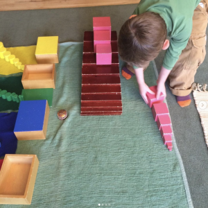 Child building the pink tower at Montessori Garden